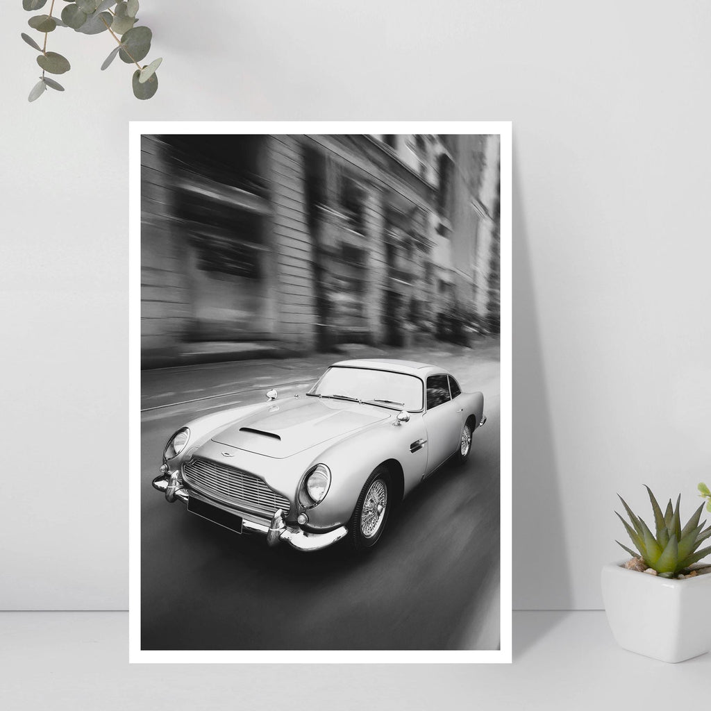 Framed black and white print of a classic car on a city street.