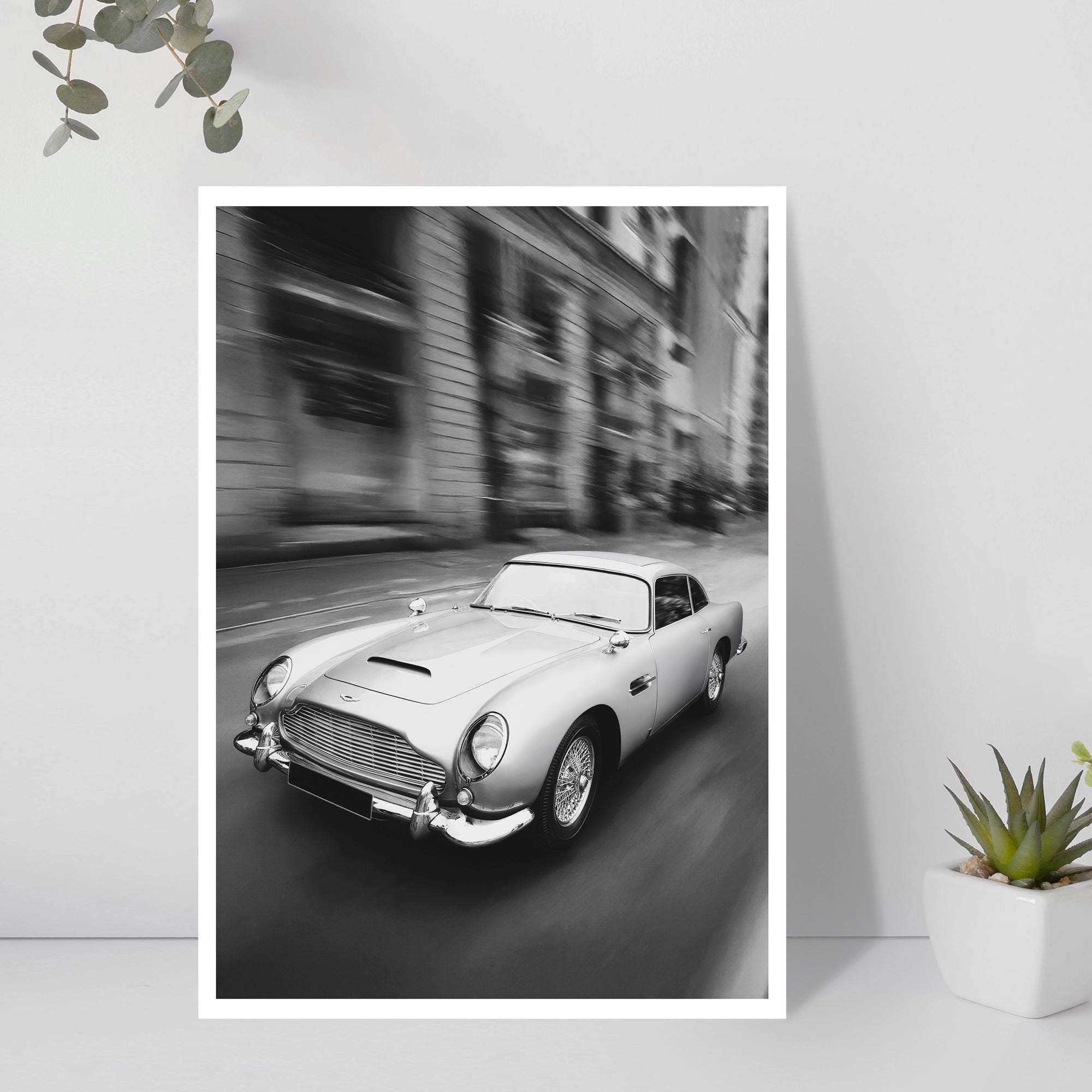 Framed black and white print of a classic car on a city street.