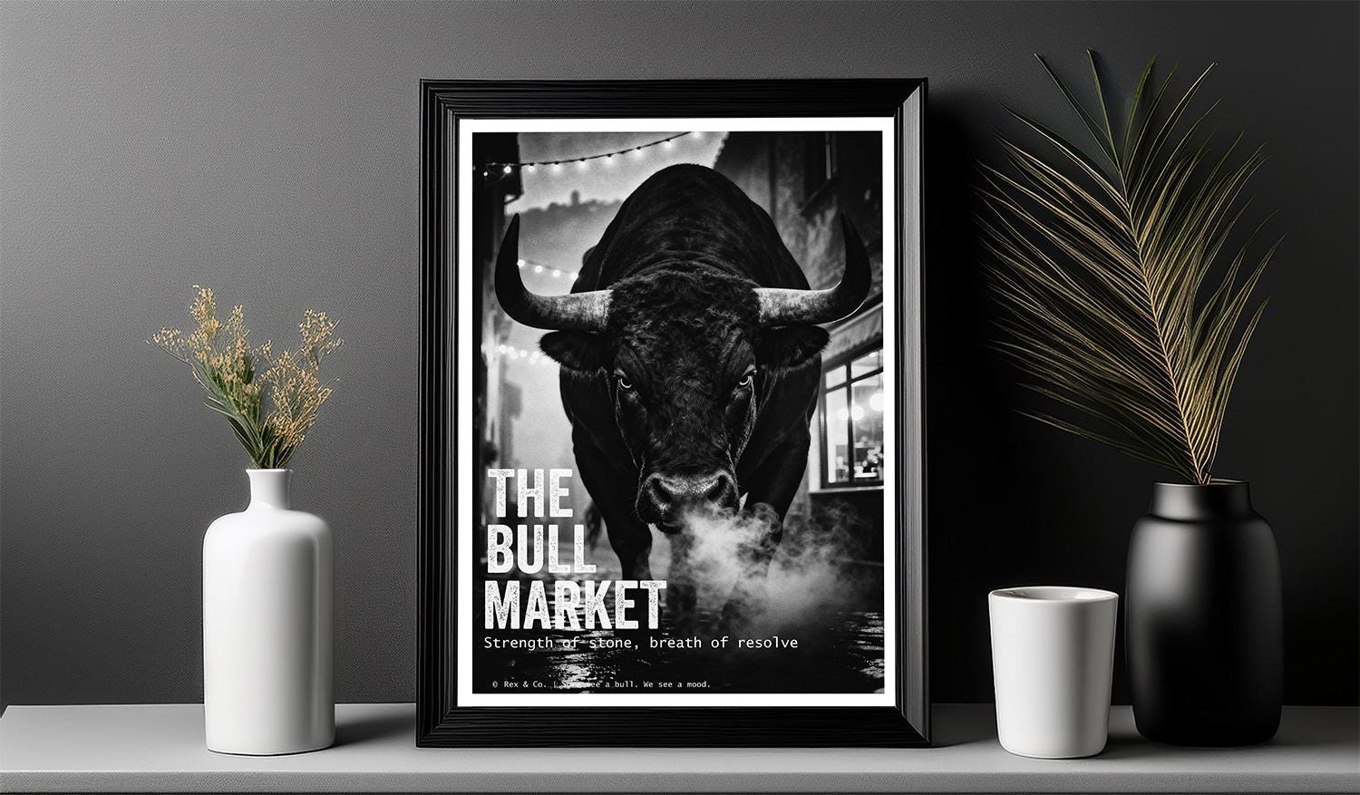 Framed poster of a bull with 'The Bull Market' text on a shelf with decorative items.