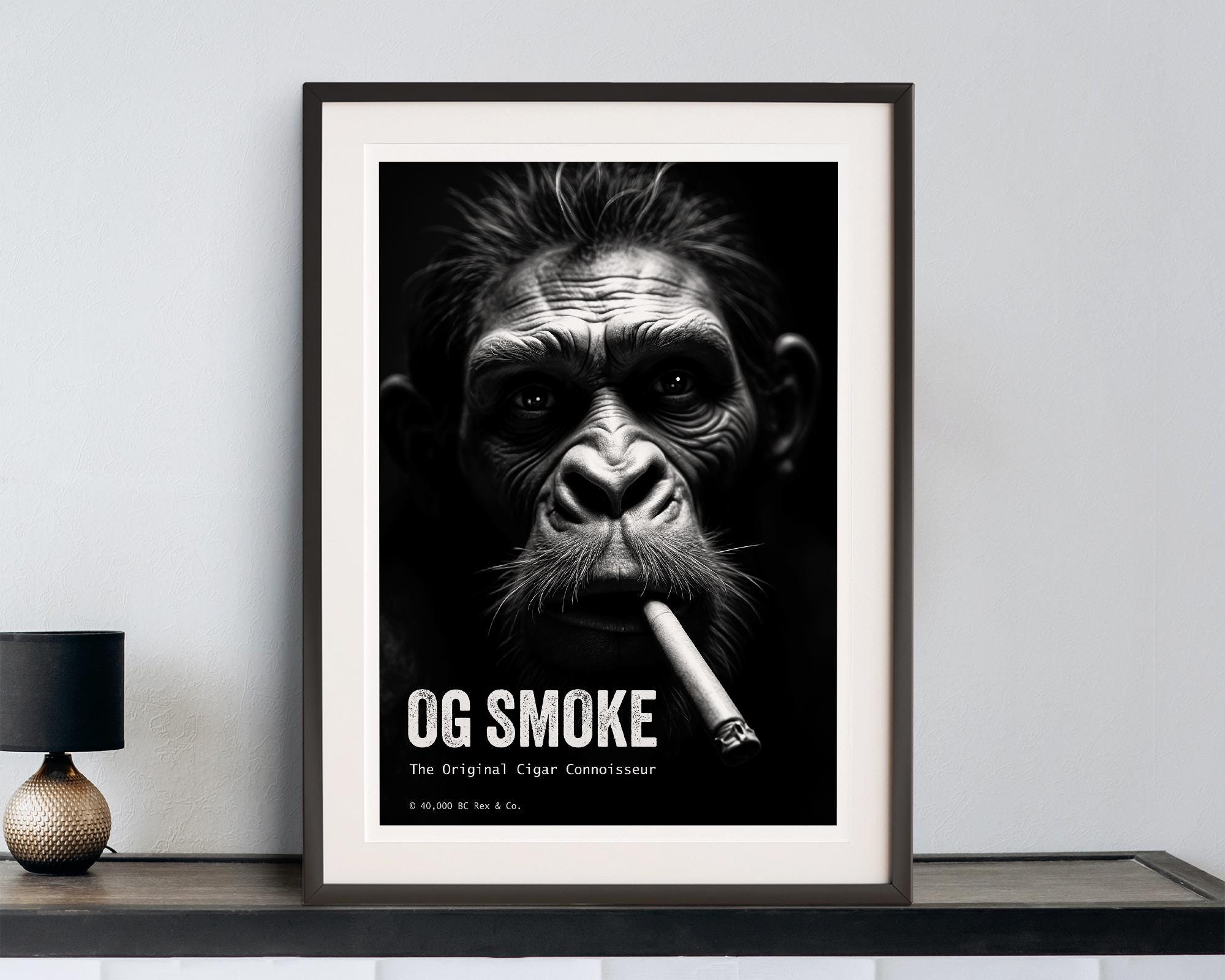 Framed poster of a cave man smoking a cigar with 'OG Smoke' text on a wall.