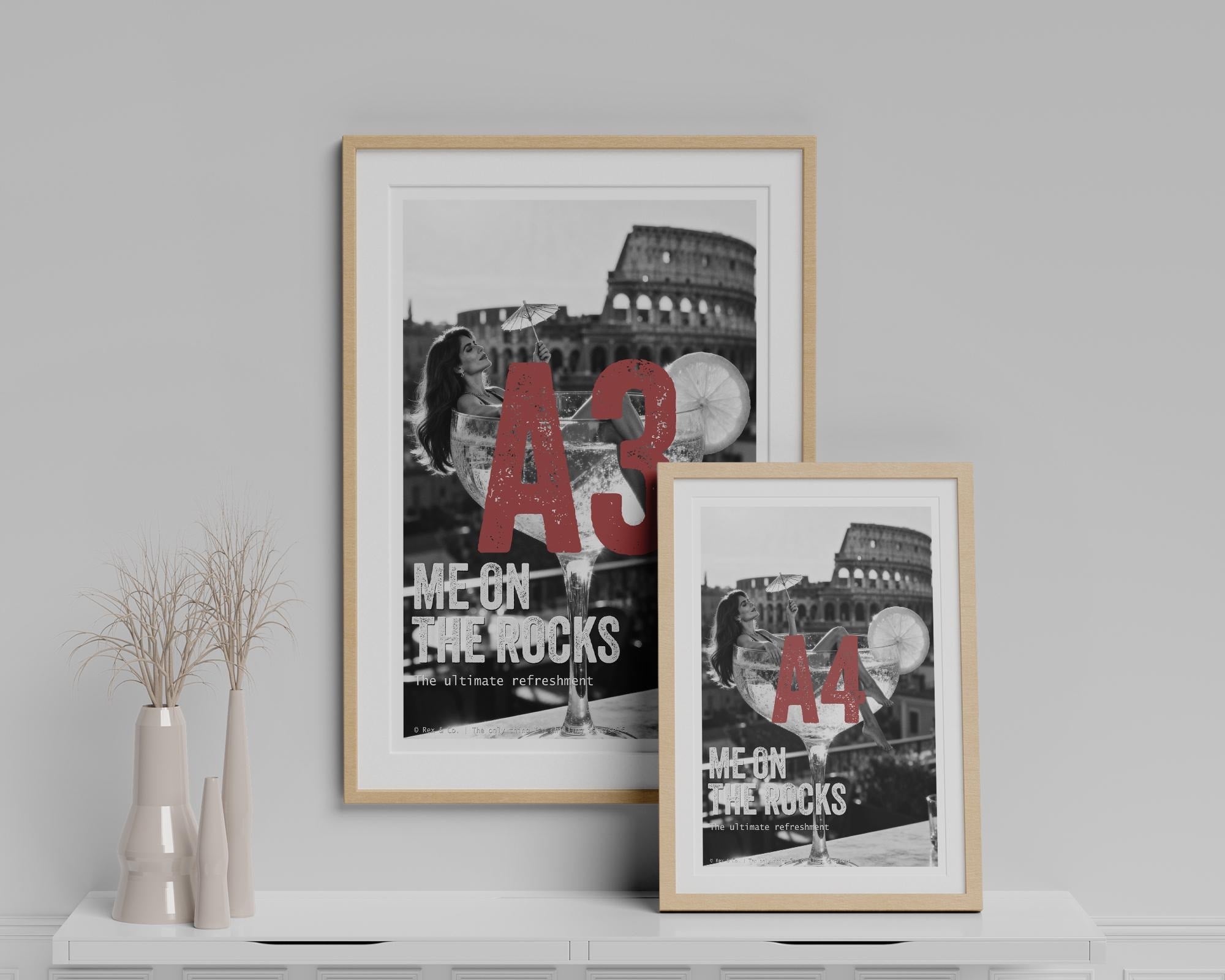 Two framed posters with text and images of a building on a white surface.