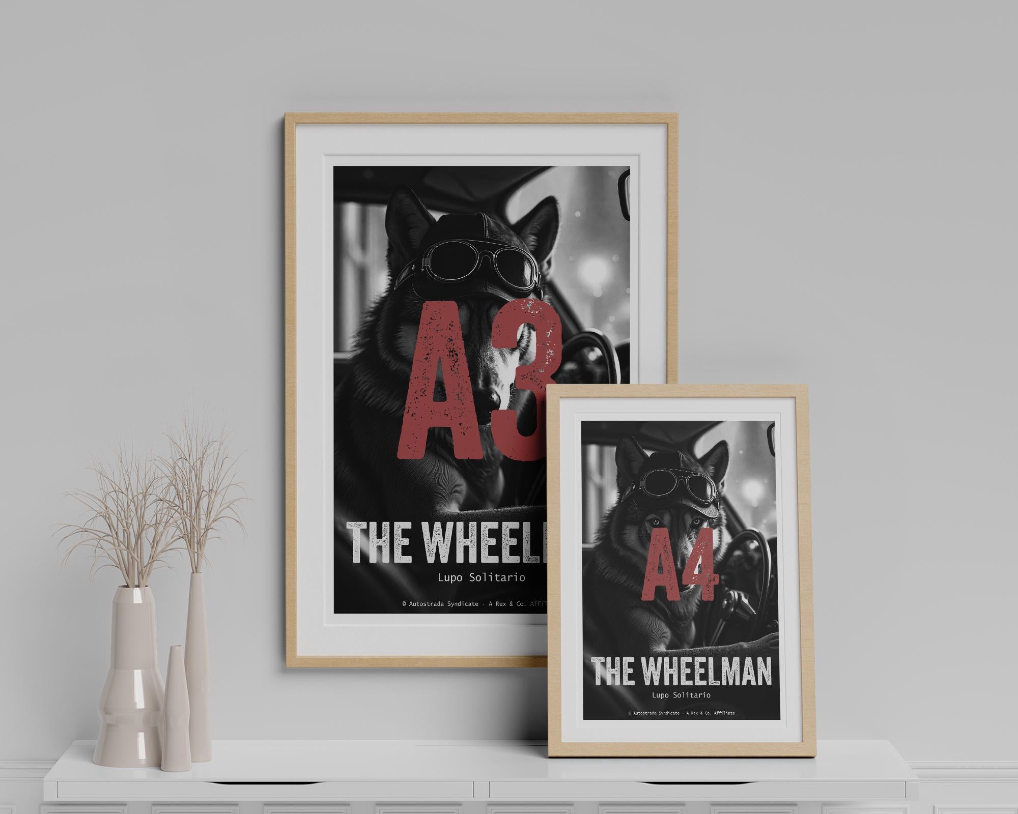 Two framed posters of 'The Wheelman' on a shelf with decorative vases.