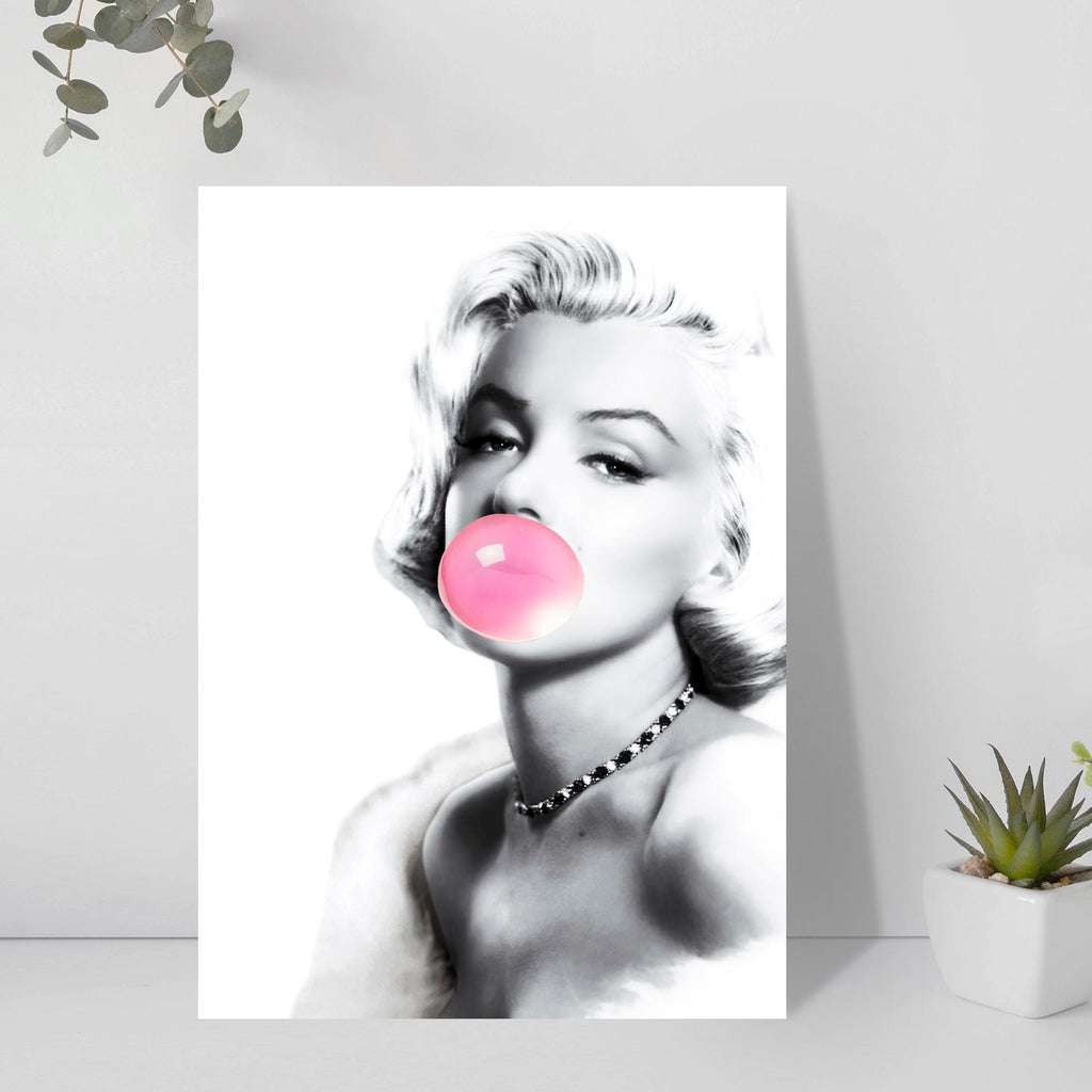 Black and white portrait of Marilyn Monroe with a pink bubble gum bubble on a light gray background.