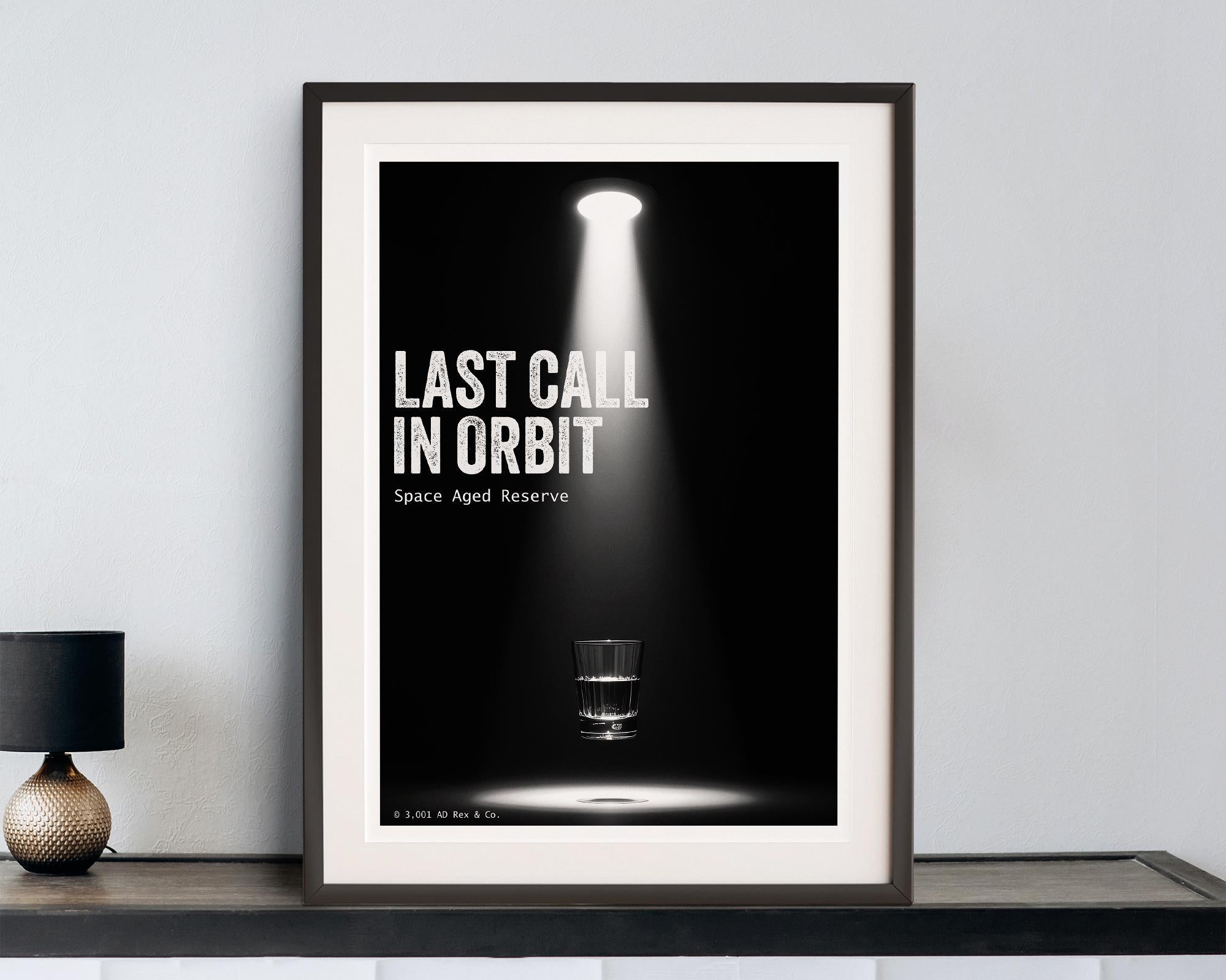 Framed poster with 'Last Call in Orbit' text on a dark background, displayed on a shelf.