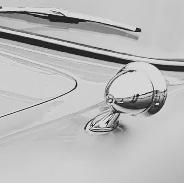 Close-up of a car's chrome mirror on a light gray background