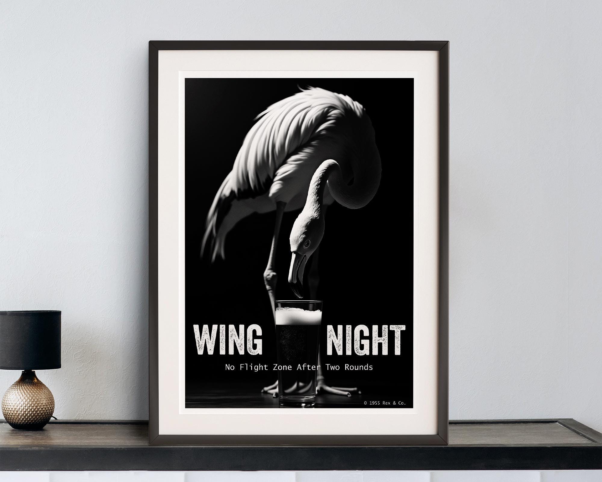 Framed poster of a flamingo with text on a wall