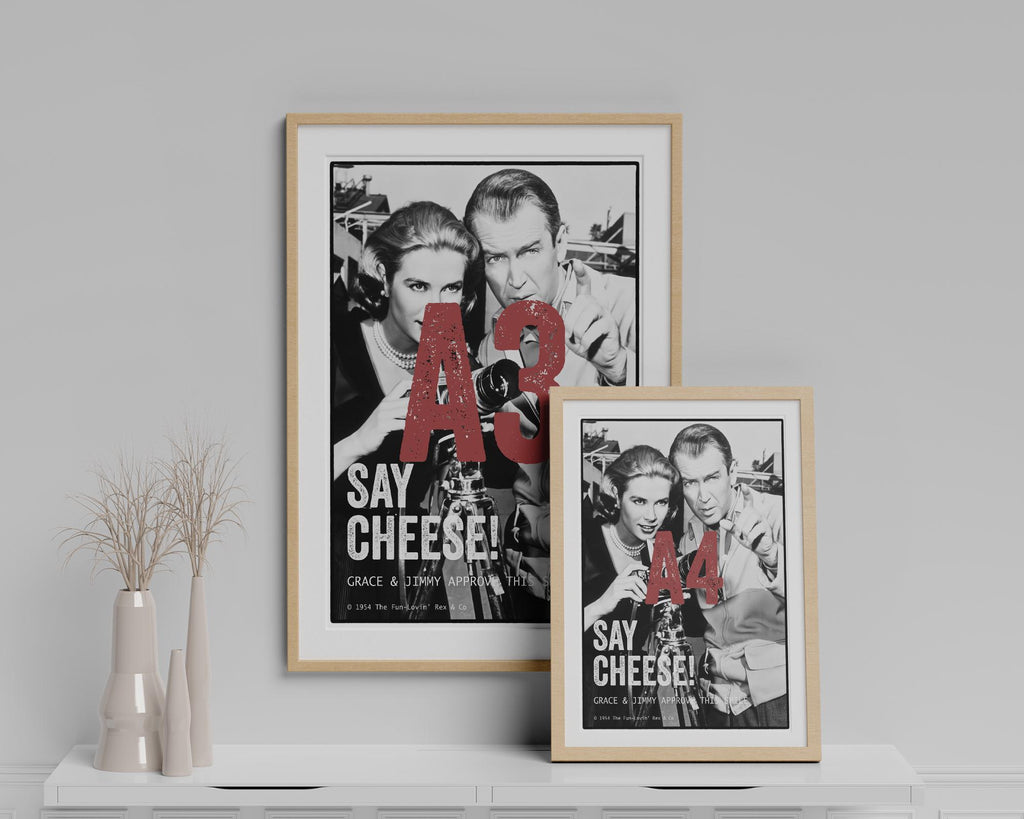 Two framed posters on a white shelf with a light gray wall background