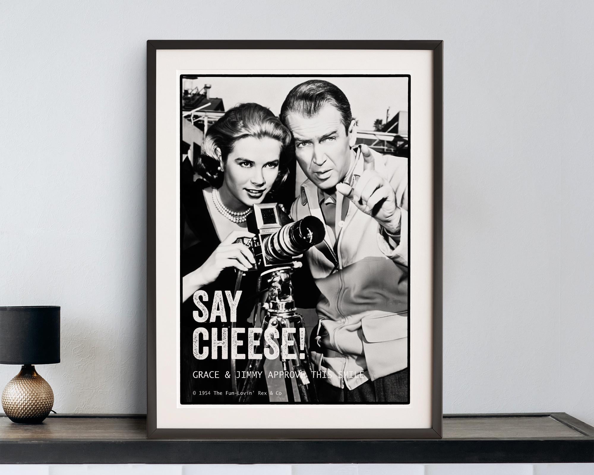 Framed black and white poster of Grace Kelly and James Stewart with a camera, featuring the text 'Say Cheese! Grace & Jimmy'.
