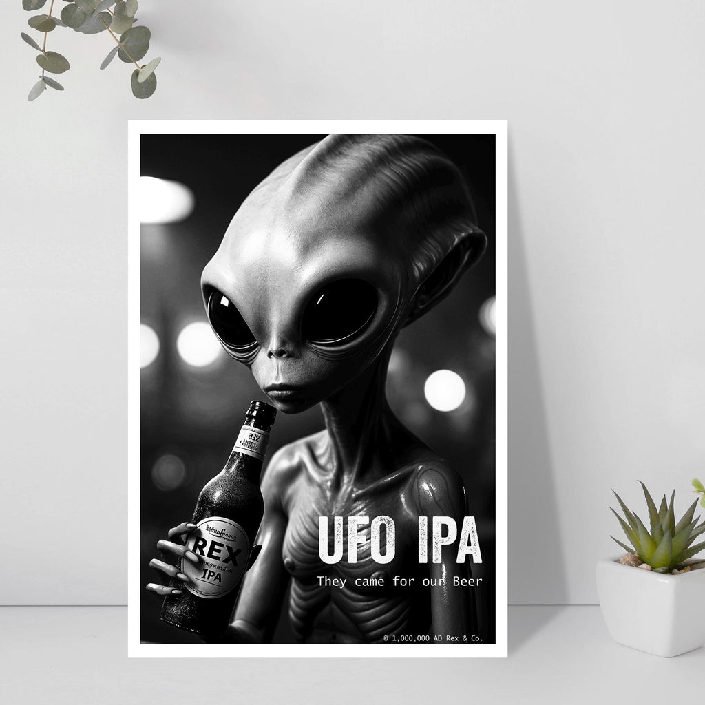 Poster of an alien holding a beer bottle with 'UFO IPA' text, framed on a wall.