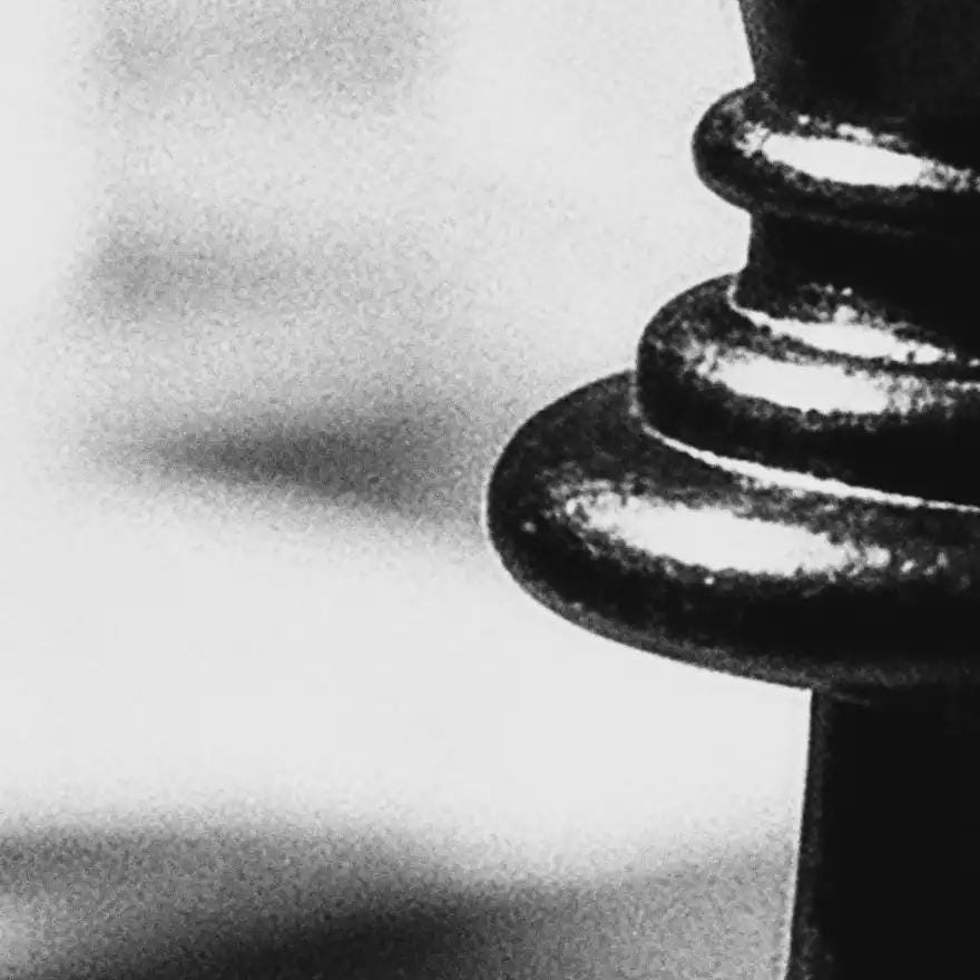 Close-up of a black chess piece on a white background