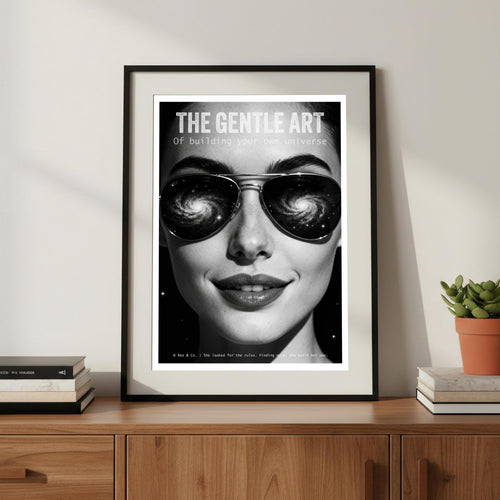 Framed poster with a woman's face wearing sunglasses on a wooden shelf.