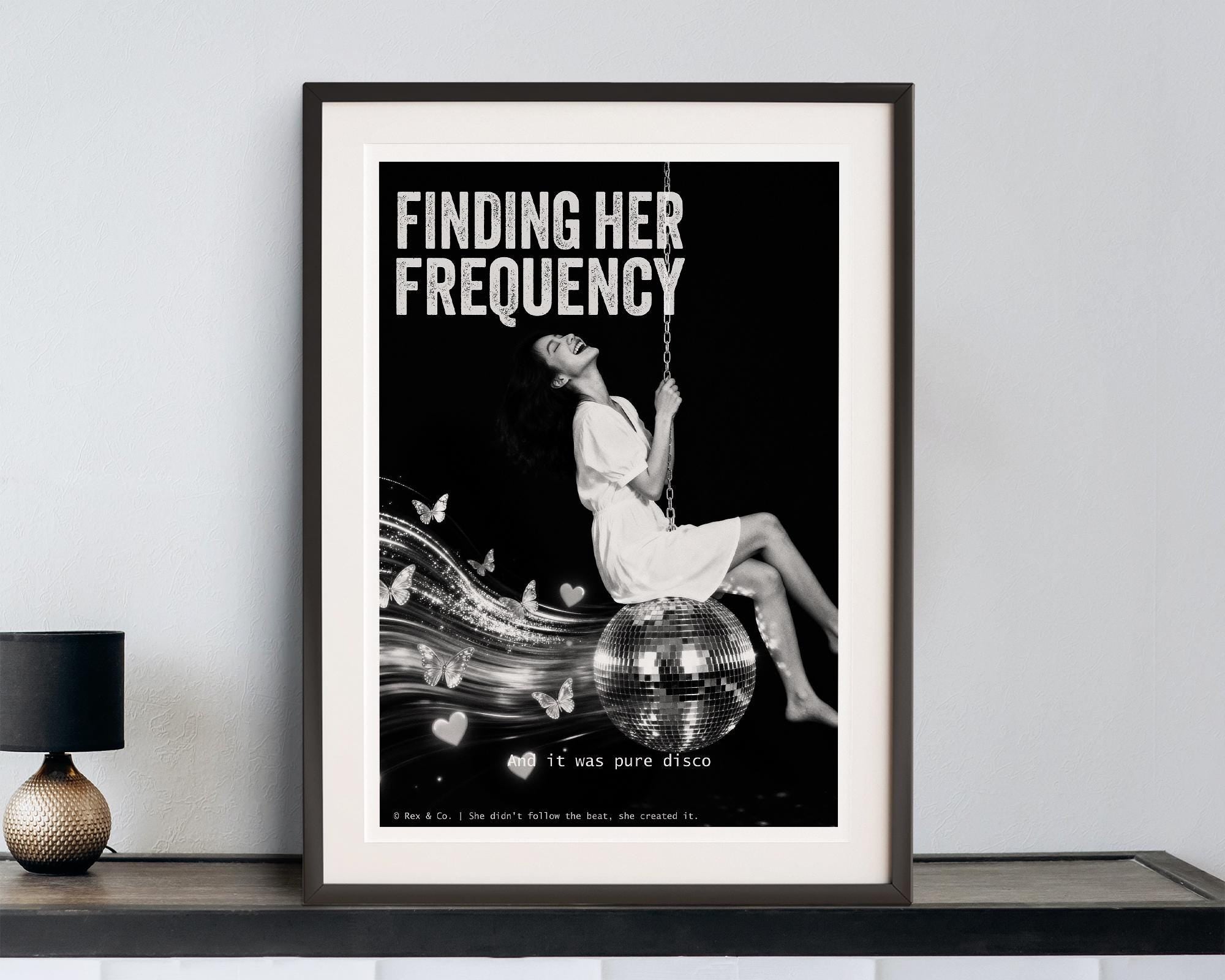 Framed poster with a woman on a swing and text 'Finding Her Frequency' in a modern interior setting.