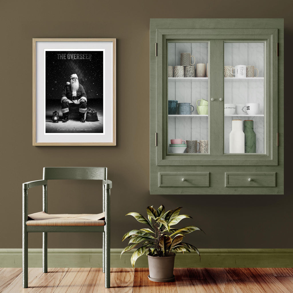 Room interior with a framed poster of Santa Claus, green cabinet, chair, and plant on a wooden floor.