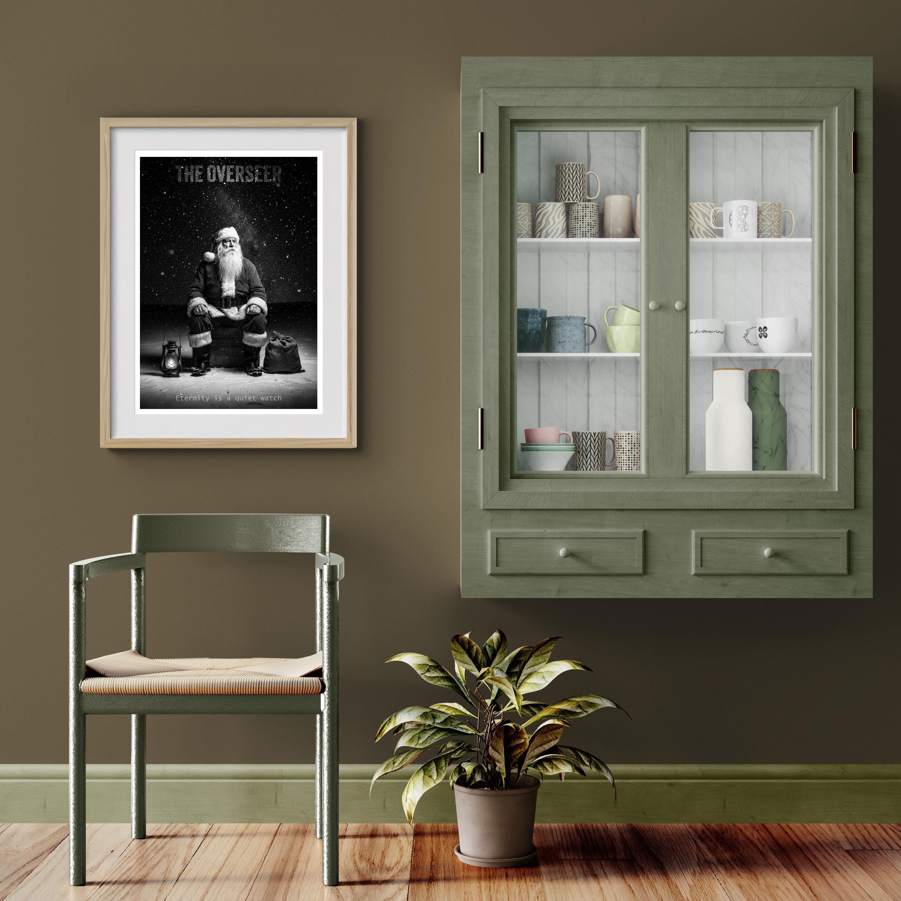 Room interior with a framed poster of Santa Claus, green cabinet, chair, and plant on a wooden floor.