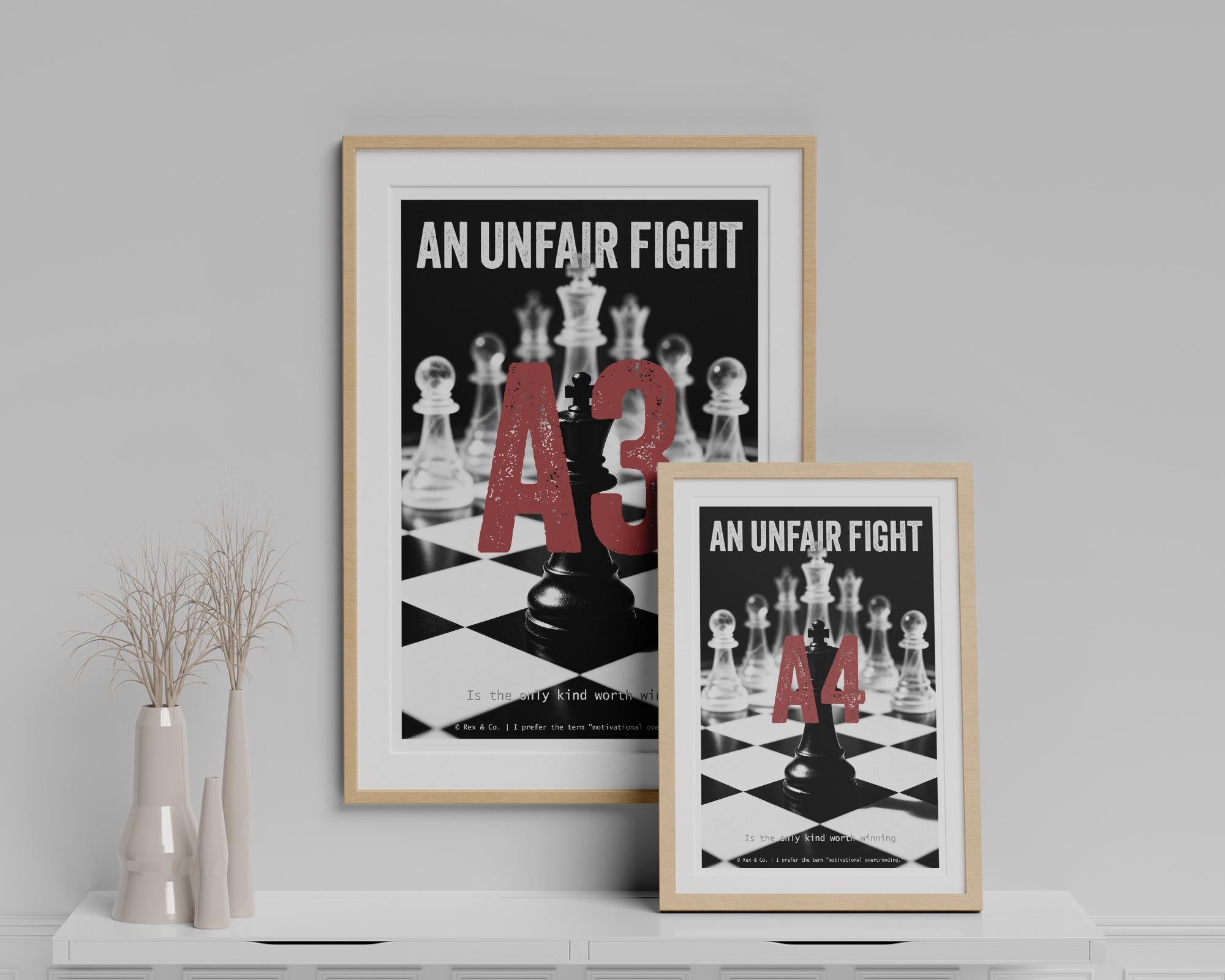Two framed posters on a shelf with chess-themed text and design.